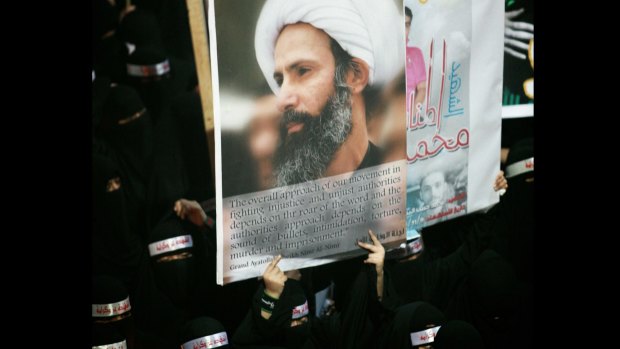 Saudi anti-government protesters carry a poster of cleric Nimr al-Nimr in 2012.