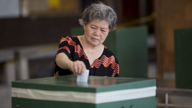 A voter casts a ballot in Bangkok.