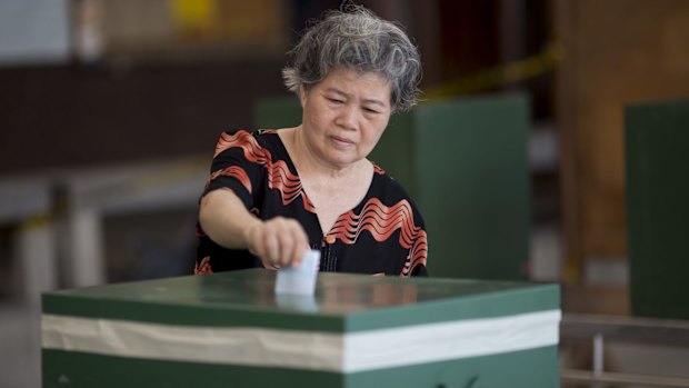 A voter casts a ballot in Bangkok.