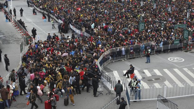 Policemen control thousands of stranded passengers entering Guangzhou Railway Station after trains were delayed.