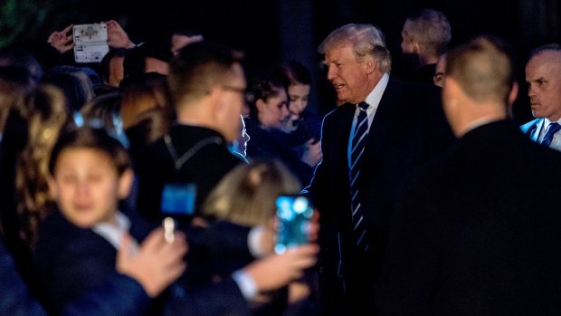 President Donald Trump greets guests to the South Lawn on Saturday night