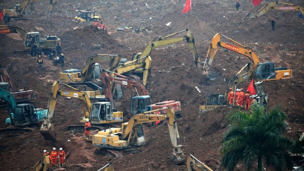 Rescuers use machinery to move earth in the search for potential survivors following a landslide in Shenzhen, in south China's Guangdong province on Monday. 