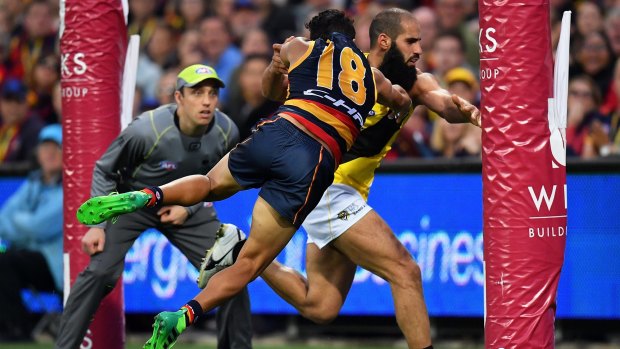 Rushed behind: Adelaide's Eddie Betts and Bachar Houli tangle on the goal line.