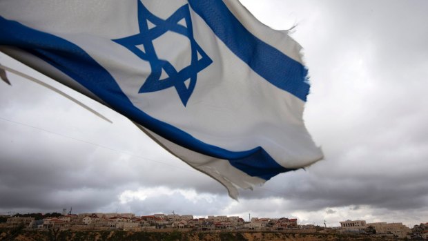 An Israeli flag flies on a hill near the West Bank Jewish settlement of Elazar,