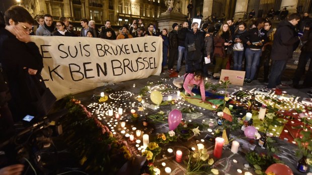 A banner reading "I am Brussels" behind flowers and candles to mourn for the victims at Place de la Bourse in the centre of Brussels.