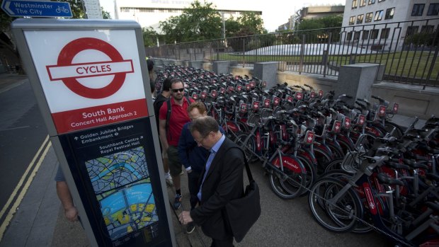 People queue to hire cycles from a city bike-sharing scheme in London on Thursday.