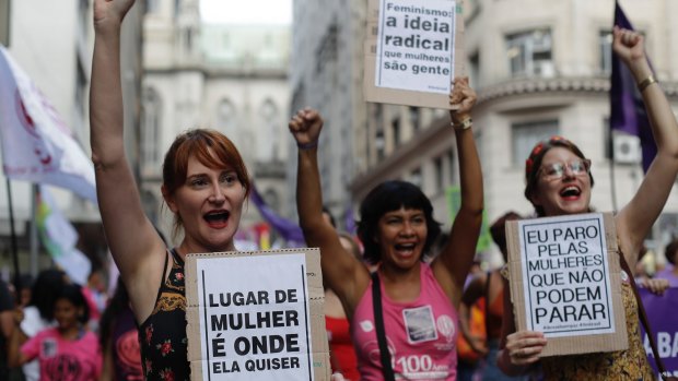 Activists march holding signs that read in Portuguese "A woman's place is where ever she wants" and "I strike for women who can't strike," in Sao Paulo, Brazil.