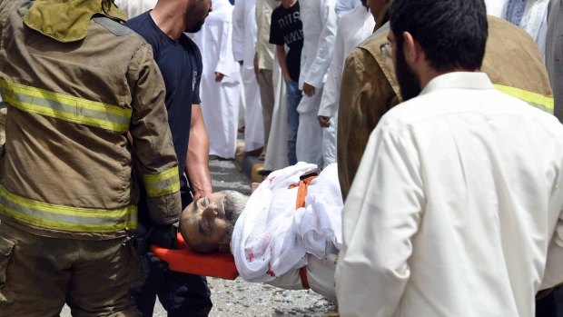 A wounded man is helped moments after a deadly explosion claimed by the Islamic State group during Friday prayers at the Imam Sadiq Mosque in Kuwait City.