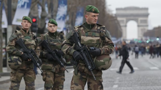 Tensions high: French soldiers patrol the Champs Elysees in Paris on Friday.