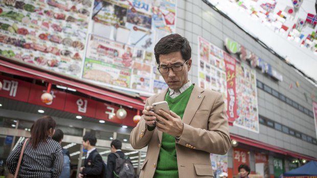 Choi Hyun-joon, a North Korean defector in Seoul who hired a middleman in China to help him connect with relatives, checks text messages on his mobile phone.