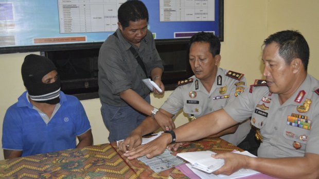 From left, seated: Captain Yohanis Humiang with head of the people smuggling division of Nusa Tenggara Timur, Ibrahim, and Rote police chief Hidayat.