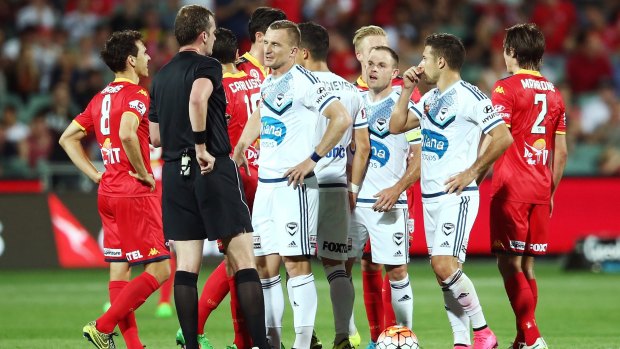 Melbourne Victory players speak to referee Peter Green after he gave Leigh Broxham a second yellow card.