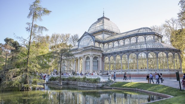 Tourists and locals gather outside the Crystal Palace in the Retiro Park in Madrid.