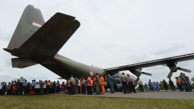 Indonesian officers carry coffins with the remains of passengers of AirAsia flight QZ8501 before being sent to Surabaya.