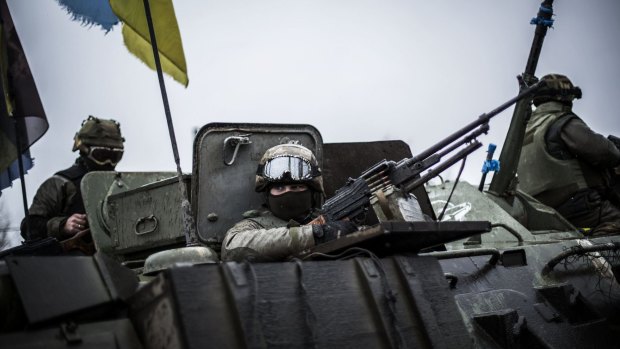 Ukrainian soldiers are seen in an armoured vehicle topped with a Ukrainian flag near the city of Artemivsk, in the Donetsk region.