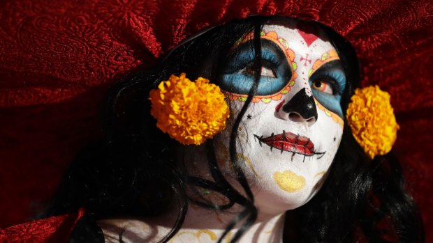 A woman dressed as Mexico's iconic 'Catrina' awaits the start of the grand procession of the Catrinas, part of the Day of the Dead celebrations in Mexico City.