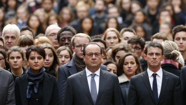 French President Francois Hollande, centre, flanked by French Prime Minister Manuel Valls, right, and French Education Minister Najat Vallaud-Belkacem, centre left, stands among students during a minute of silence in the courtyard of the Sorbonne University in Paris on Monday. 