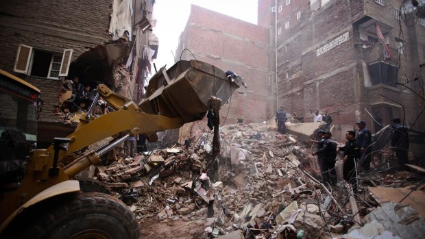 Rescue workers try to deal with the immense amount of rubble.