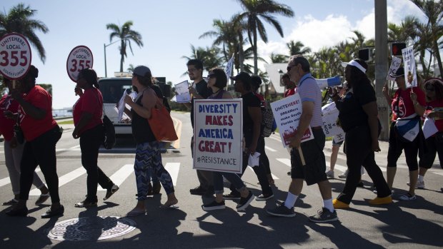 Demonstrators hold signs during a protest ahead of Donald Trump's arrival at Mar-a-Lago on Tuesday.
