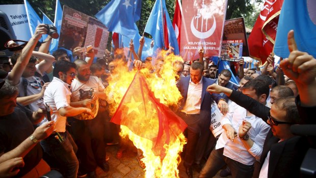 Demonstrators set fire to a Chinese flag during a protest near China's consulate in Istanbul this week.