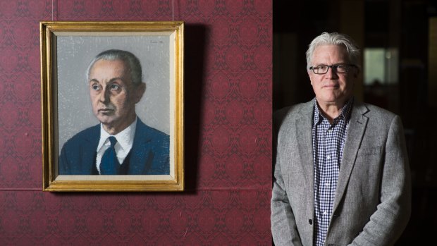 Curator Nat Williams with a portrait of Sir Rex Nan Kivell in a show of Kivell's collection at the National Library of Australia.