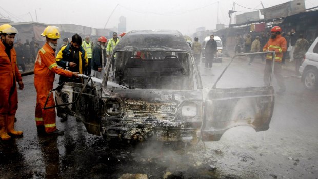 Pakistani fire fighters try to extinguish a vehicle on fire following a suicide blast, in Peshawar, Pakistan.
