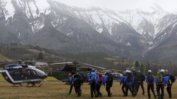 French Police and Gendarmerie Alpine rescue units gather on a field as they prepare to reach the crash site.