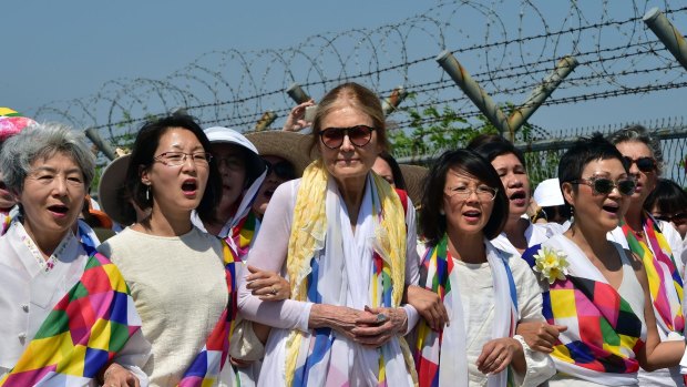 US feminist Gloria Steinem (centre) and South Korean peace activists march along a military fence at a checkpoint in Paju.
