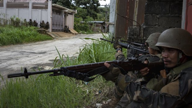 Soldiers take positions while evading sniper fire in Marawi.