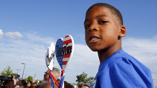 Aarington Traylor holds signs calling for justice during a protest against what demonstrators call police brutality in McKinney, Texas.