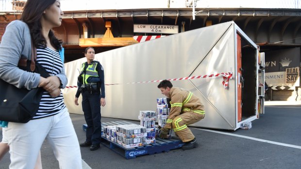 Red Bull rollover. Emergency services remove the freight from the truck that rolled over at the Flinders Street Bridge.