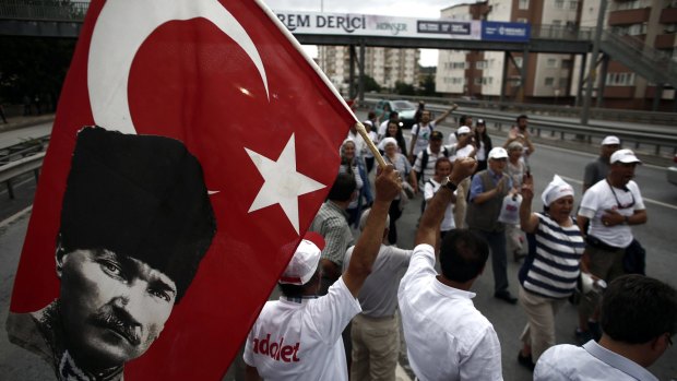 A demonstrator holds a flag with a picture of Mustafa Kemal Ataturk, secular founder of modern Turkey, during the 20th day of a 425-kilometre march in Kocaeli, Turkey.