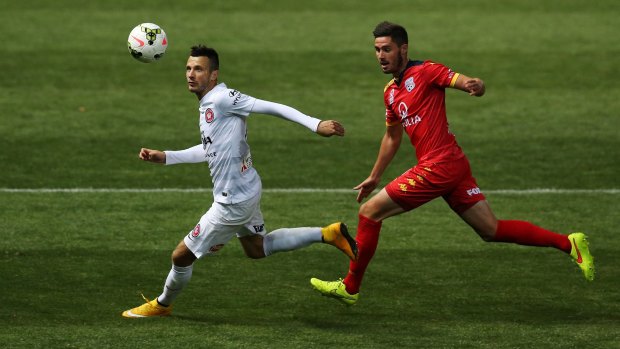 Nikita Rukavytsya of the Wanderers competes for the ball with Adelaide United's Dylan McGowan.