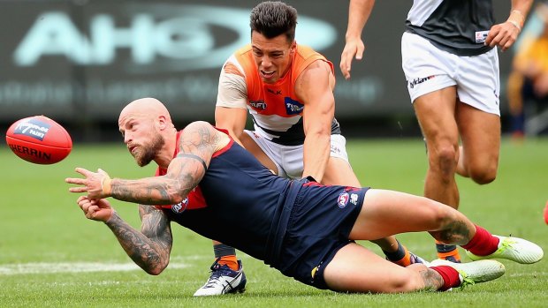 Grounded: Nathan Jones of the Demons gets the ball away despite the tackle of Dylan Shiel.