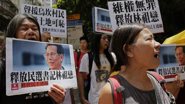 Protesters hold pictures of the Wukan village's 70-year-old leader, Lin Zuluan, during a protest in Hong Kong on Tuesday. 