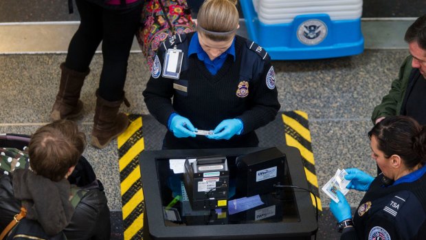 Transportation Security Administration (TSA) officers check passenger's identification at a security checkpoint at Ronald Reagan National Airport in Washington, DC.