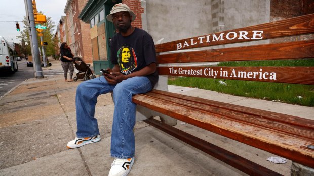 James Lewis waits for a bus in the Hollins Market area of Baltimore.