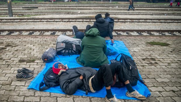 Migrants rest at the railway station in the Greek village of Idomeni.