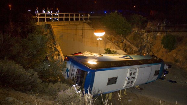 A bus lies by a highway after it rolled over into a gully near the town of Albufeira, southern Portugal.