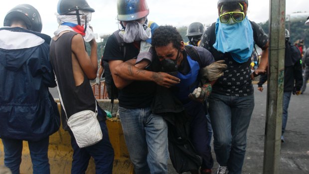 A demonstrator is carried away by others after being injured during protests in Caracas, Venezuela.