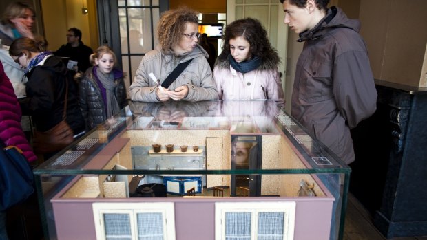 Visitors look at scale models of the secret annex.