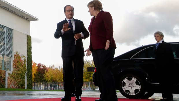 French President Francois Holalnde and German Chancellor Angela Merkel arrive for talks in Berlin.