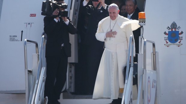 Pope Francis waves from the steps of his aircraft as he leaves the Philippines for Rome on Monday.