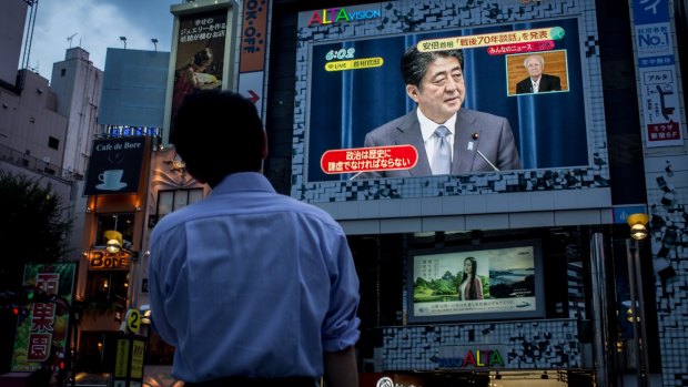 Mr Abe's speech on a big screen in Tokyo. 