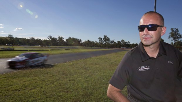 Marcos Ambrose watches Scott Pye test the Team Penske-DJR V8 Supercar at Queensland Raceway last week.