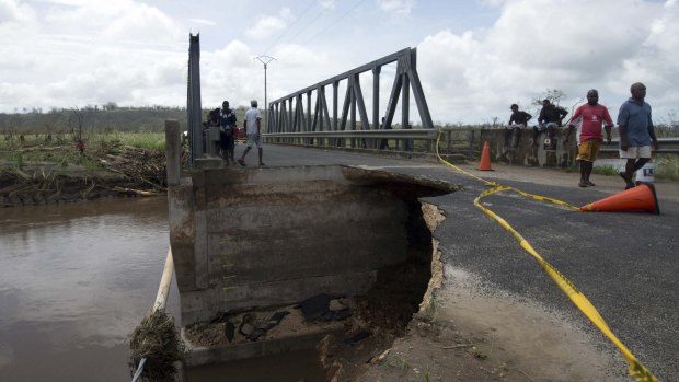 Residents stand near a bridge damaged by Cyclone Pam near Port Vila.