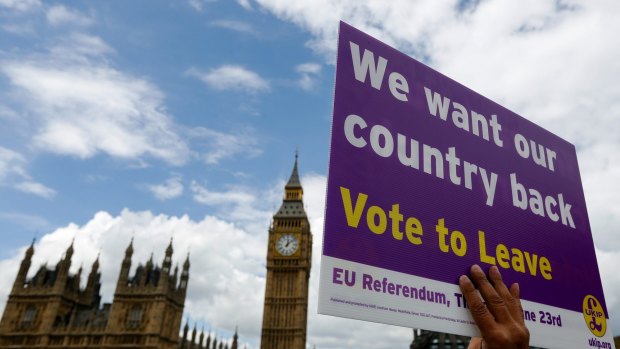 A demonstrator for the "Leave" campaign holds a placard outside Houses of Parliament in London.