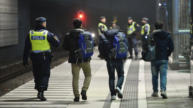 Swedish police escort three men from a train at Hyllie station outside Malmo. Sweden was looking to deport between 60,000 and 80,000 asylum seekers in coming years.