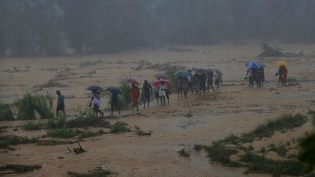 Sri Lankans walk towards safety during after heavy rain in Elangipitiya village.