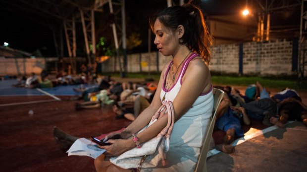 A pregnant woman awaits processing during a night time mass arrest of suspected drug users at a shanty community on in Manila last week.